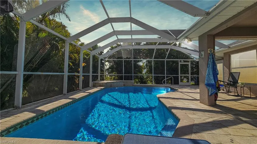 View of swimming pool with a patio and glass enclosure