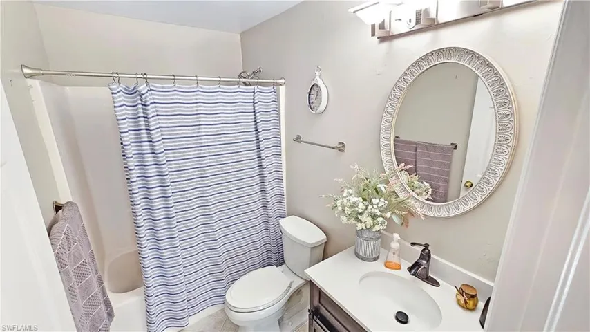 Full bathroom with shower / tub combo, vanity, and toilet