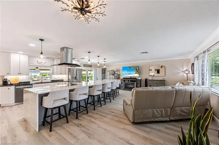 Living room with light tile floors, sink, and ornamental molding