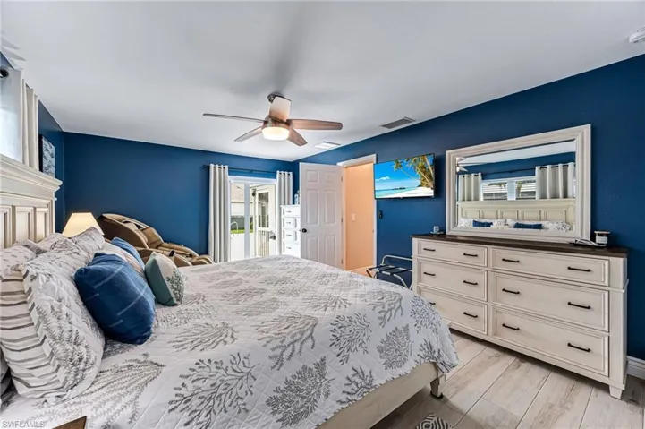 Bedroom with light tile floors, access to exterior, and ceiling fan