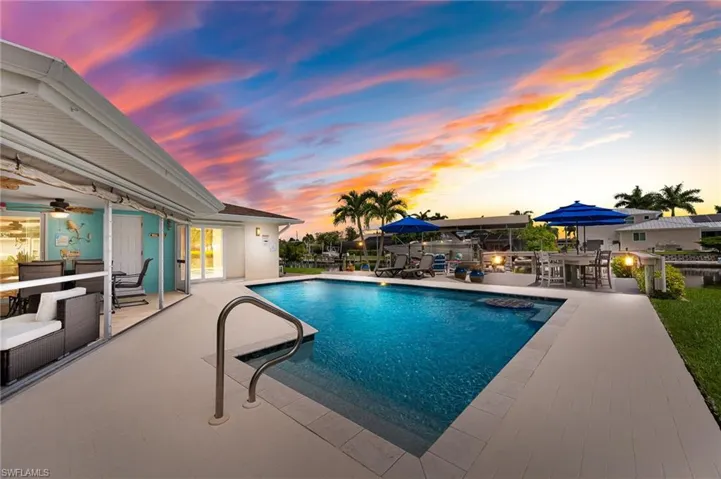 Pool at dusk featuring patio area, pool deck