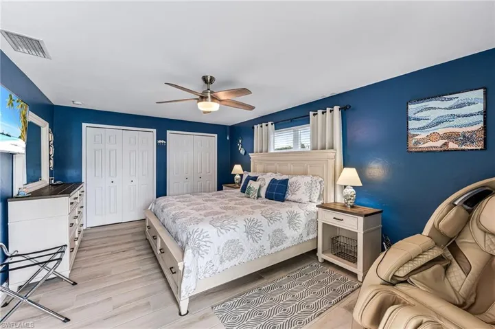 Bedroom featuring two closets, ceiling fan, and light tile floors