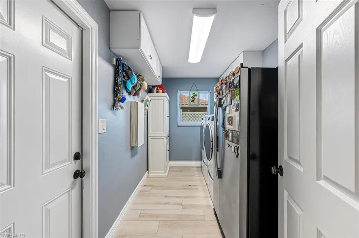Laundry area with separate washer and dryer, lots of storage and light tile floors
