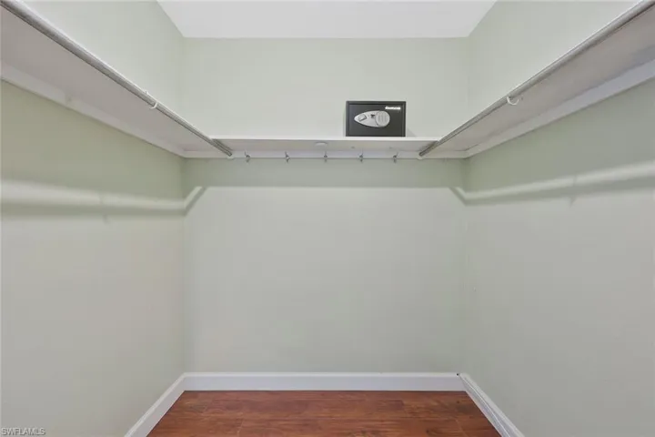 Walk in closet featuring dark wood-style floors