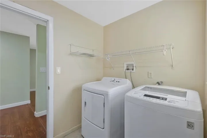 Laundry room with independent washer and dryer and wood finished floors