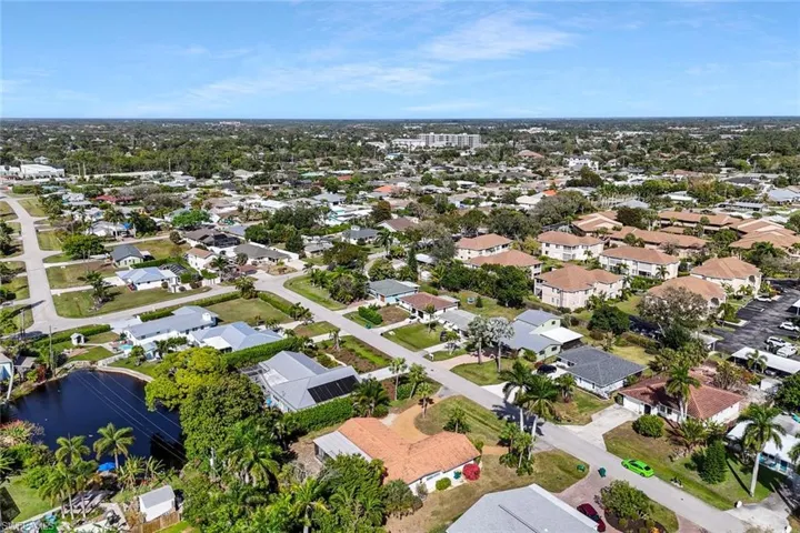 Aerial view of property and surrounding area featuring nearby suburban area