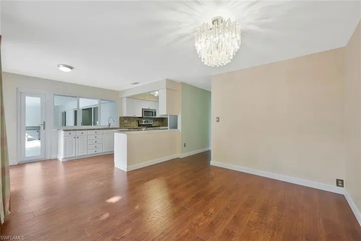 Family room with dark wood-style flooring and hanging lights