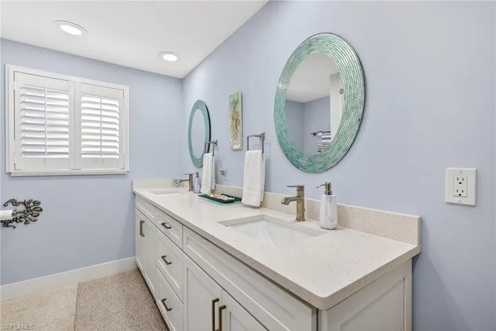 Bathroom featuring double vanity and baseboards