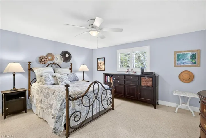 Primary Bedroom with light colored carpet and a ceiling fan