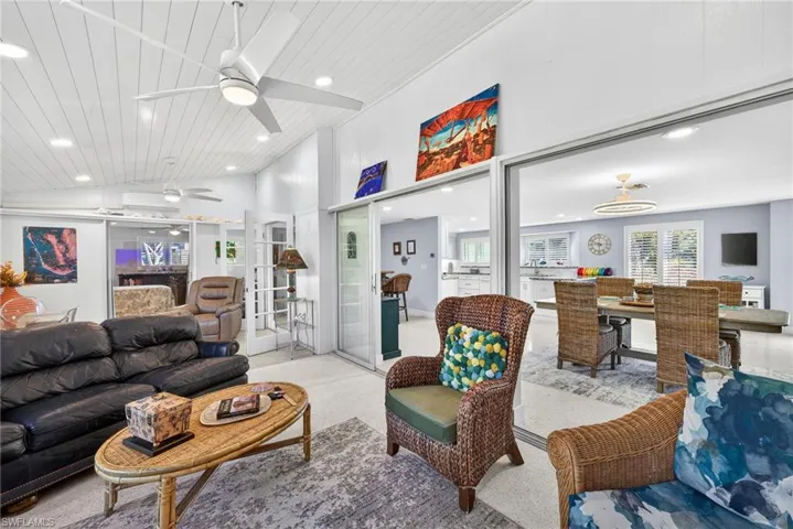 Carpeted living area with a ceiling fan, recessed lighting, and a vaulted wooden ceiling