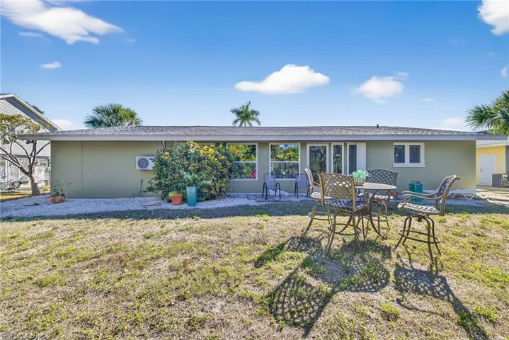 Rear view of property with stucco siding, a yard, and a patio area