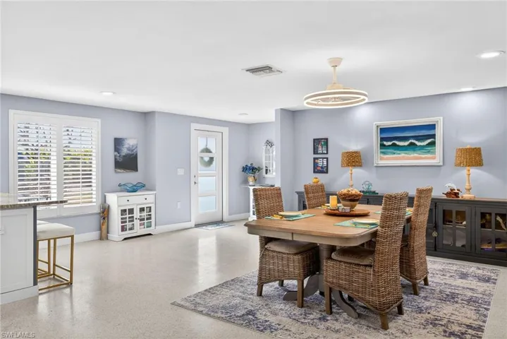 Dining area with dark speckled floor and recessed lighting