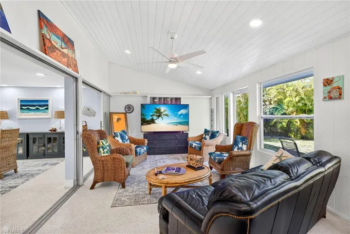 Living room with a ceiling fan, recessed lighting, a vaulted wooden ceiling, and light carpet