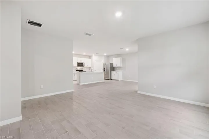 Unfurnished living room with light hardwood / wood-style floors and sink