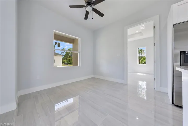 Empty room with ceiling fan and baseboards
