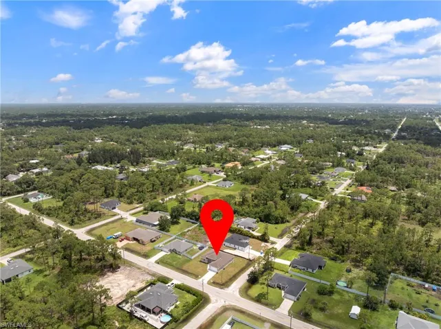 Aerial view of property and surrounding area with a heavily wooded area