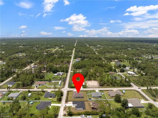 View of property location featuring a forest and nearby suburban area