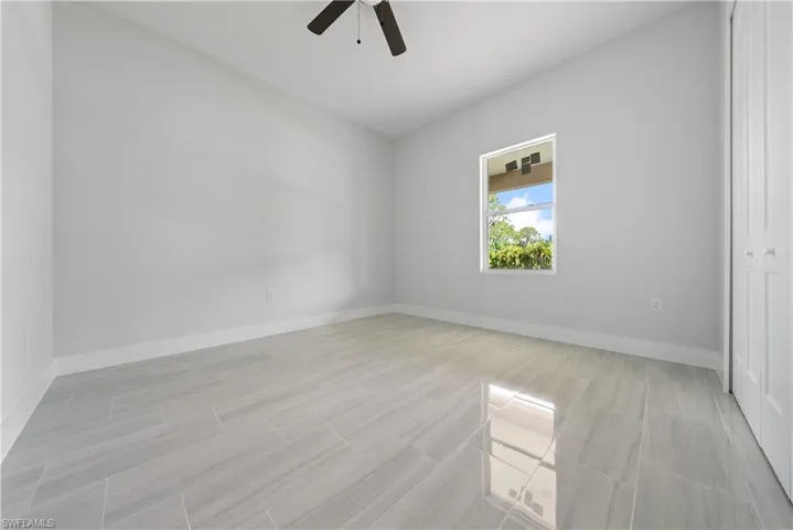 Spare room with ceiling fan and baseboards