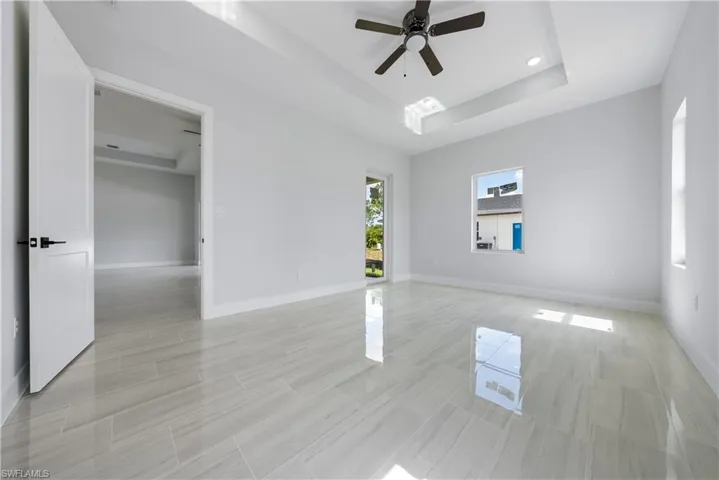 Spare room with a tray ceiling, ceiling fan, and recessed lighting