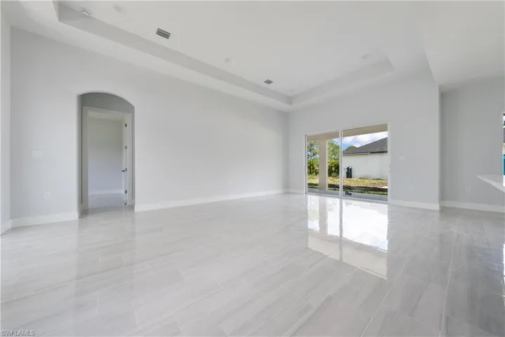 Spare room with a raised ceiling and arched walkways