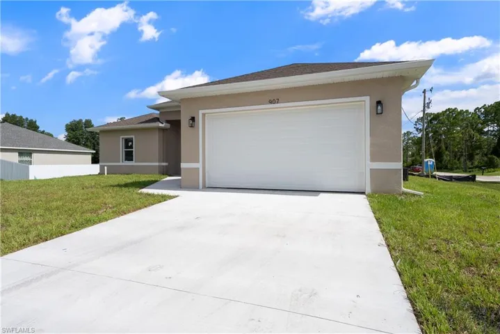 Ranch-style house with stucco siding, concrete driveway, a front lawn, and a garage