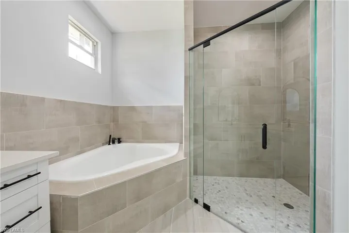 Bathroom featuring a garden tub, vanity, and a stall shower