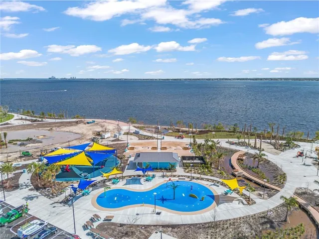 Drone / aerial view of a nearby body of water and a pool