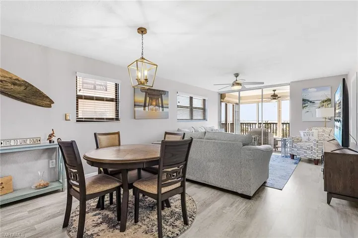 Dining area with ceiling fan, a chandelier, and light wood-style floors