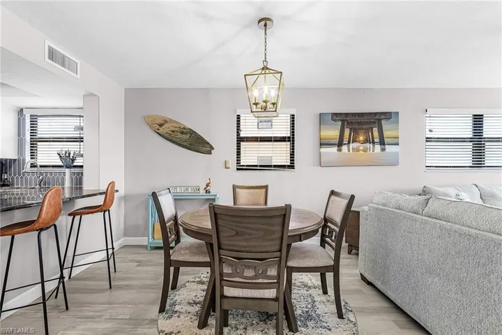 Dining space with healthy amount of natural light, light wood finished floors, and hanging lights