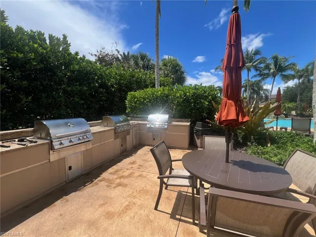 View of community pool patio / terrace with a pool, a grill, and exterior kitchen