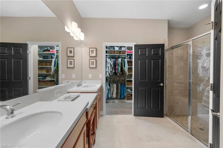 Master bedroom with dual sinks and stand-up shower