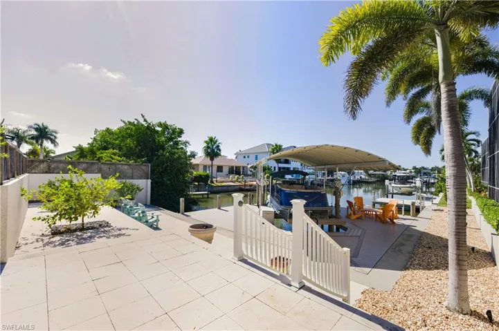 View of patio featuring boat lift, a dock, and a water view