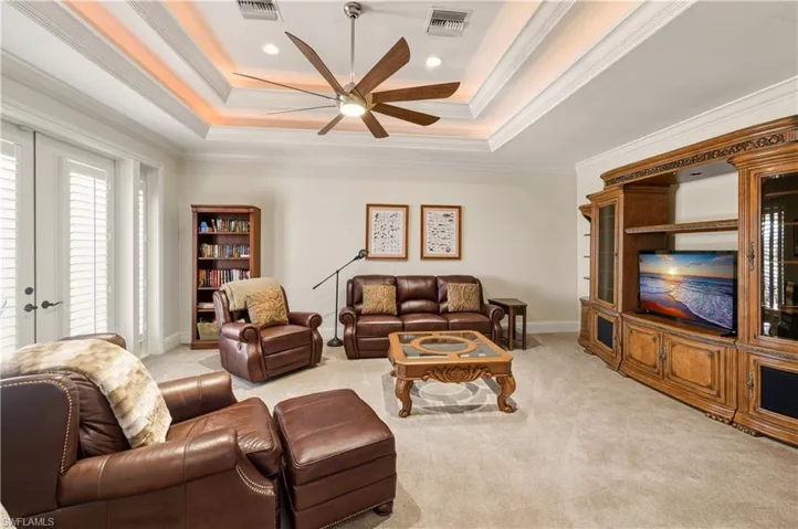 Living room with a raised ceiling, french doors, light colored carpet, ornamental molding, and recessed lighting