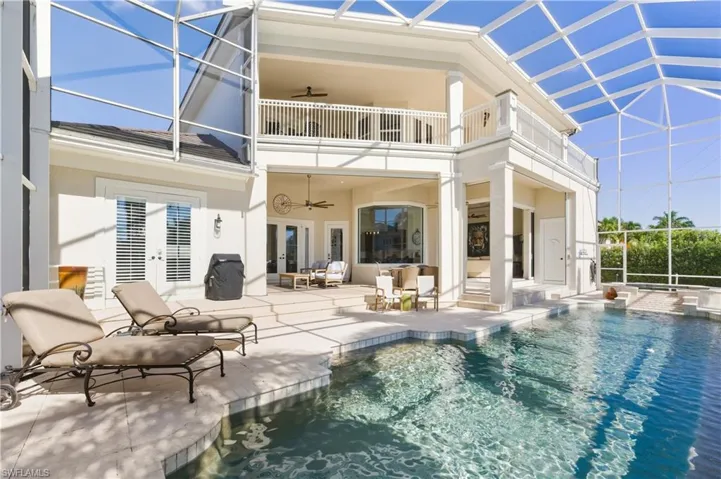 Rear view of property featuring a lanai, ceiling fan, a patio area, and a sunroom