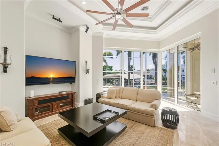 Living room with ceiling fan, crown molding, recessed lighting, and a raised ceiling