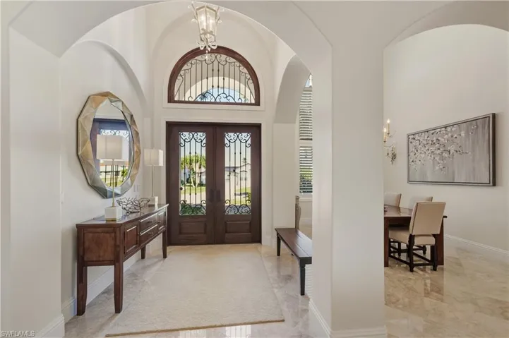 Foyer featuring a chandelier, high vaulted ceiling, and french doors