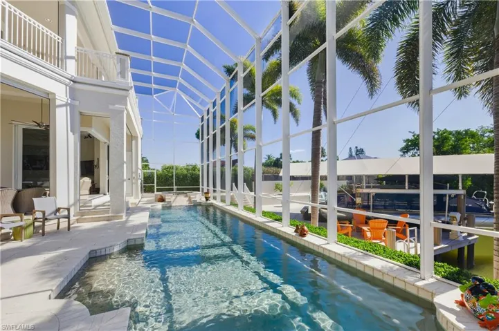 View of swimming pool with a sunroom, a patio, glass enclosure, and a pool with connected hot tub