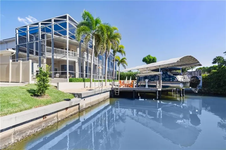 Dock featuring a lanai, boat lift, and a water view