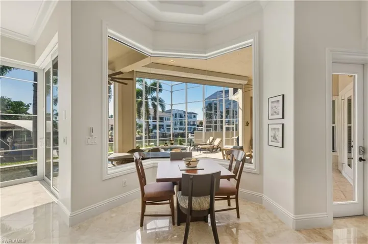 Dining area featuring crown molding and a sunroom