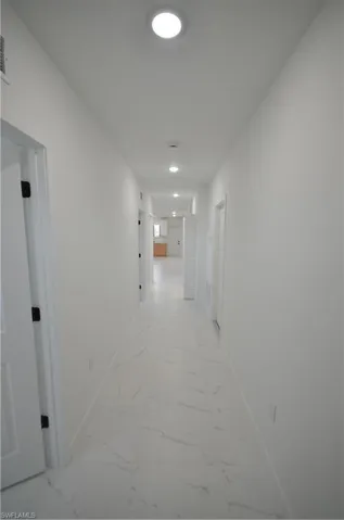 Unfurnished room featuring baseboards and marble finish floor