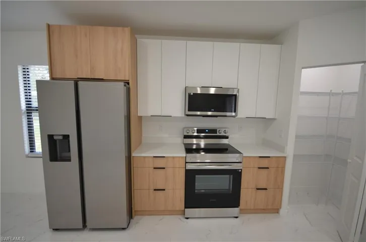 Kitchen featuring visible vents, marble finish floor, modern cabinets, a sink, and dishwasher