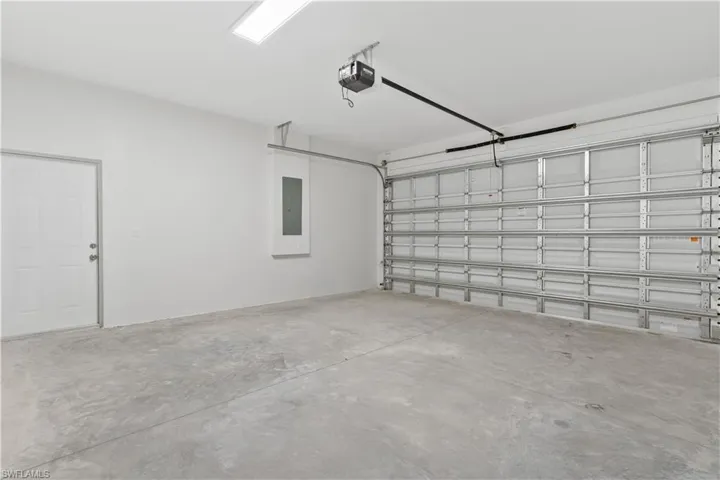Garage featuring electric panel and a garage door opener