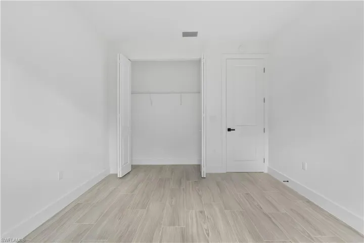 Unfurnished bedroom with wood tiled floors and a closet