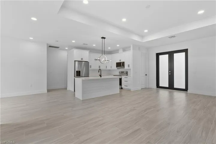Kitchen featuring open floor plan, an island with sink, stainless steel appliances, light wood-style flooring, and recessed lighting