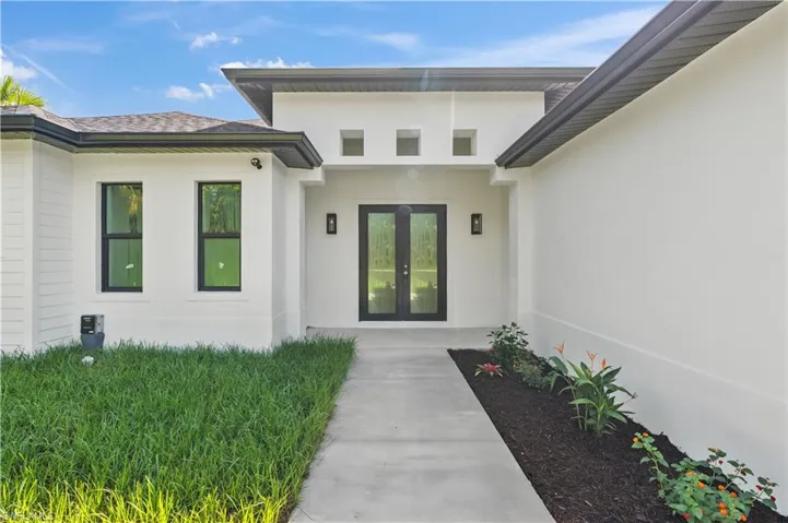 Doorway to property with stucco siding and french doors
