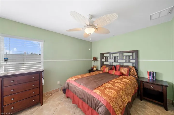 Bedroom with a ceiling fan and light tile patterned floors