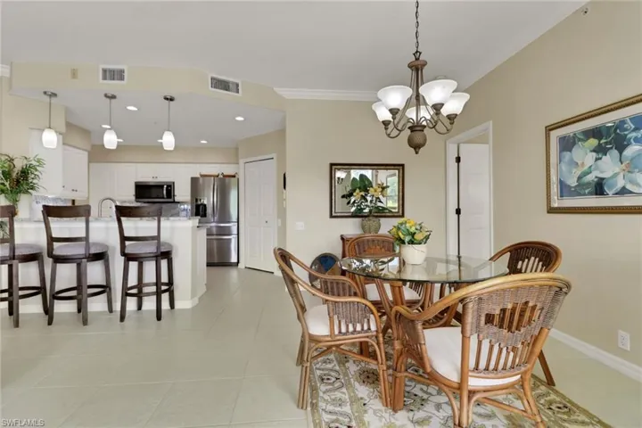 Dining area with recessed lighting, crown molding, a chandelier, and light tile patterned floors