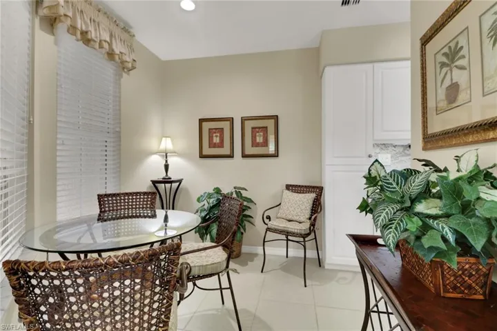 Dining space with light tile patterned flooring and recessed lighting