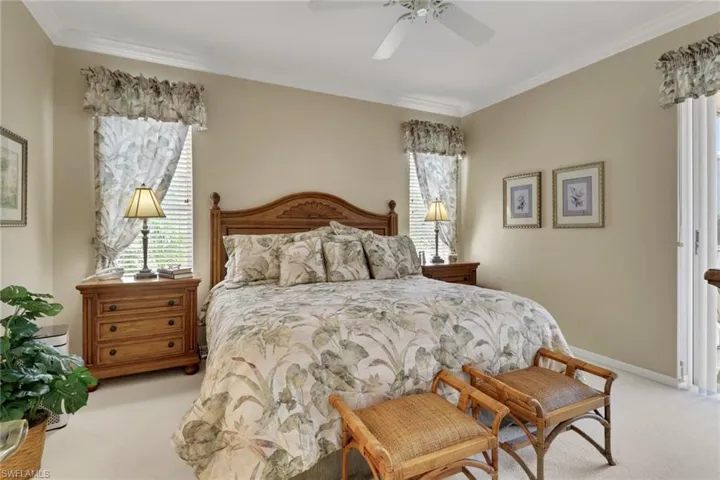 Bedroom featuring carpet, ornamental molding, and a ceiling fan