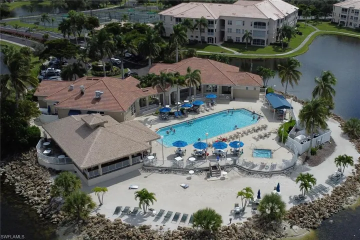 Drone / aerial view of a nearby body of water and a pool